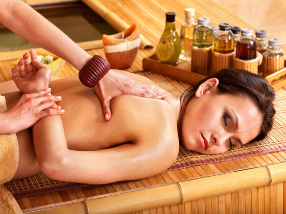 Masseurin führt eine entspannende thailändische Massage in einem ruhigen Raum durch